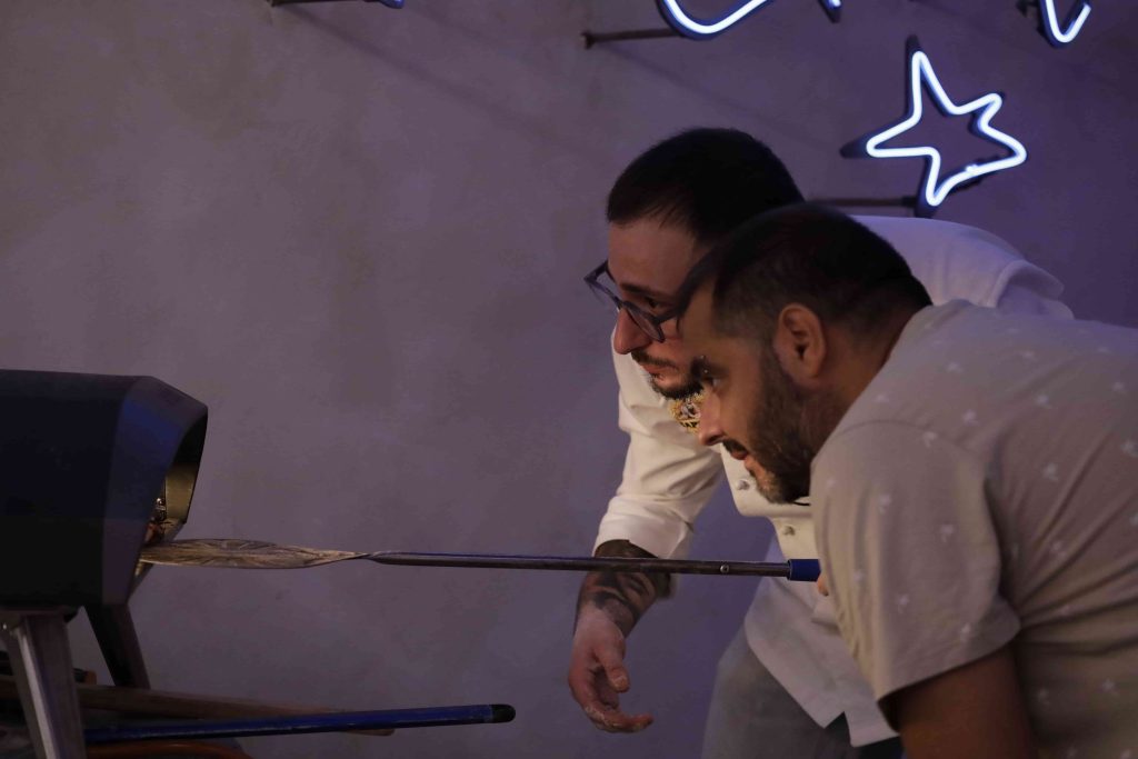 Walter y alumno poniendo pizza en el horno